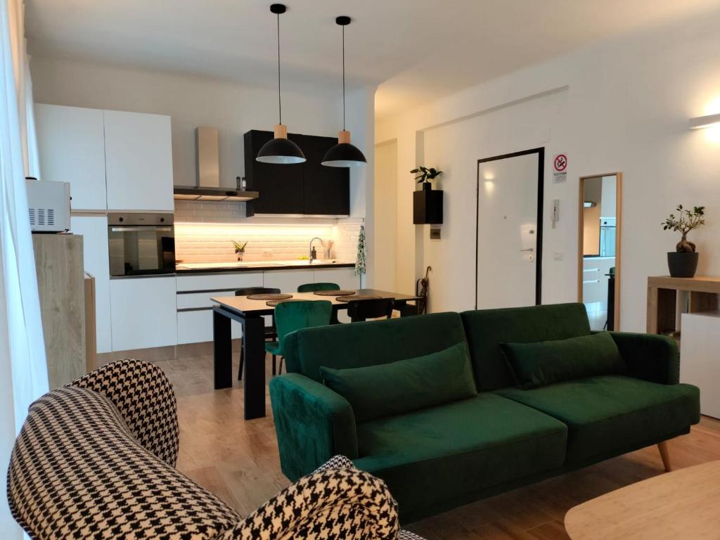 een woonkamer met een groene bank en een keuken bij B&B Tanto Piacere Taranto in Taranto