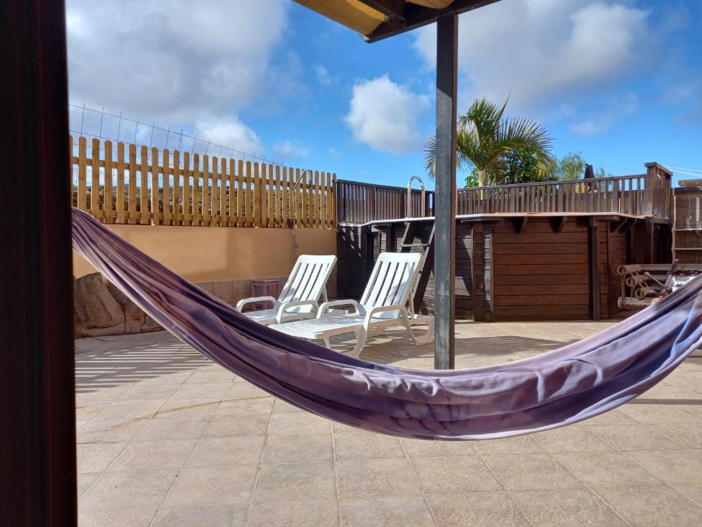 a purple hammock on a patio with two chairs at Casa Livia Pool & Sunset in Corralejo