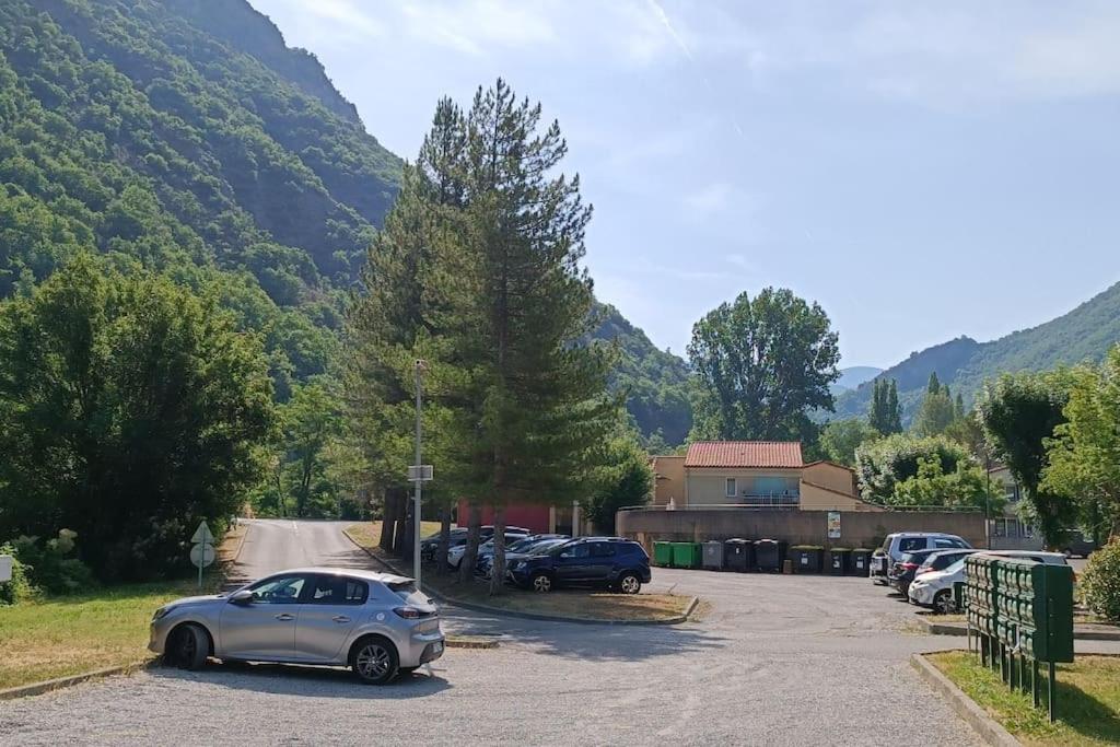 a car parked in a parking lot with mountains in the background at T2 au cœur de la nature de Digne in Digne-les-Bains