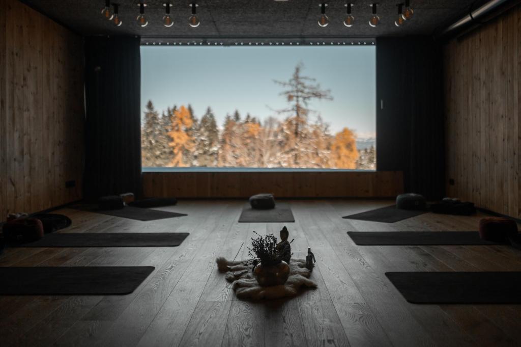 una stanza con tappetini per lo yoga sul pavimento di fronte a una grande finestra di Green Luxury Hotel Pfösl a Nova Ponente