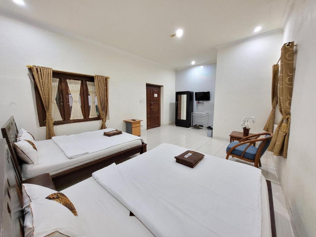 Postel nebo postele na pokoji v ubytování Ndalem Katong Guest House Ponorogo