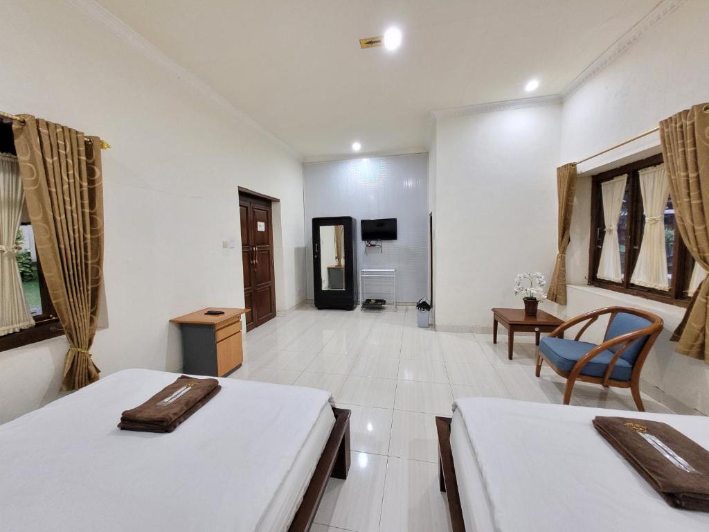 Postel nebo postele na pokoji v ubytování Ndalem Katong Guest House Ponorogo