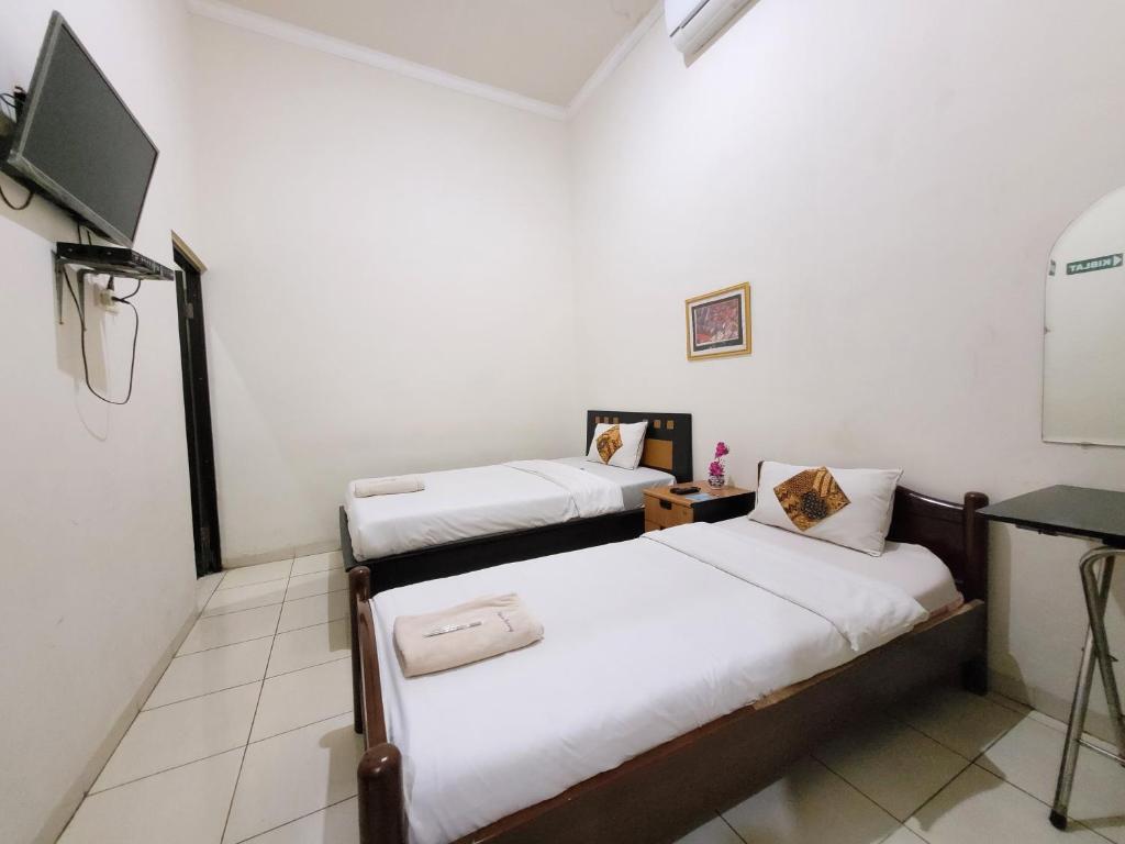 Postel nebo postele na pokoji v ubytování Ndalem Katong Guest House Ponorogo