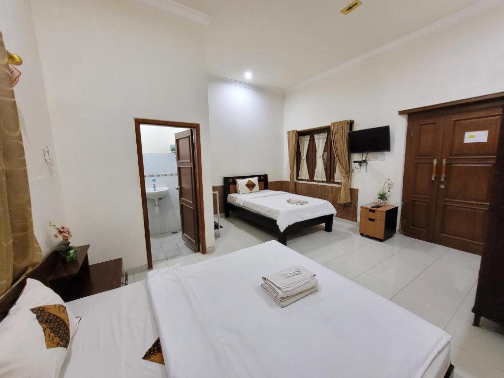 Postel nebo postele na pokoji v ubytování Ndalem Katong Guest House Ponorogo