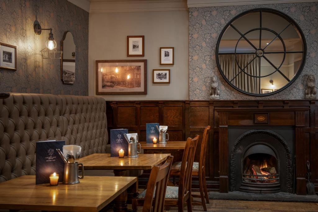 a restaurant with two tables and a fireplace at The Golden Lion at Settle in Settle