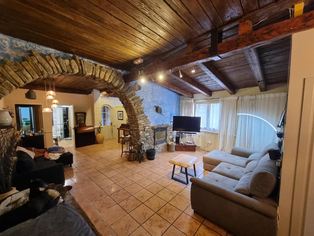 a living room with couches and a stone fireplace at BAJOS CON ENCANTO EN RIALP in Rialp