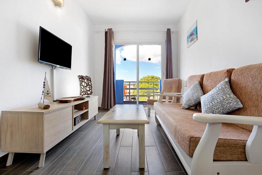 a living room with a couch and a tv at Buena Fuerte Apartamentos Marino in Tarajalejo