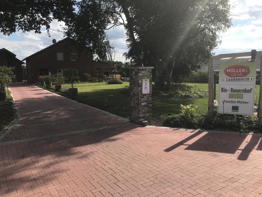 a house with a sign in a brick driveway at Pension Quellenhof in Wegberg