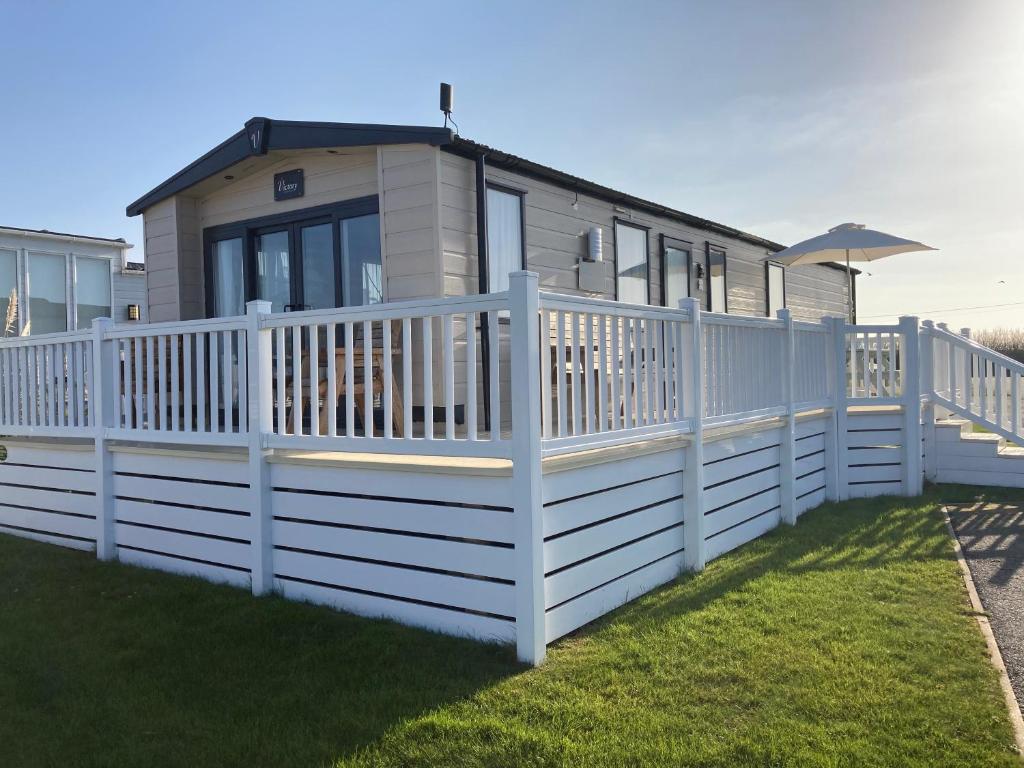 a white fence in front of a tiny house at alphi3 in Bude