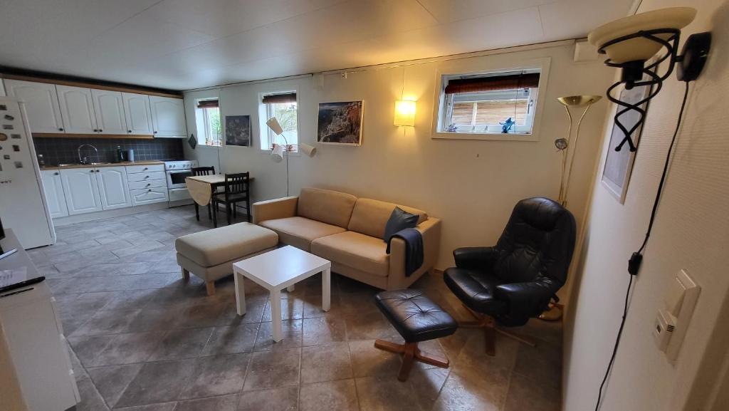 een woonkamer met een bank, stoelen en een tafel bij Flott leilighet i stille og rolig område, med gratis privat parkering! in Stavanger