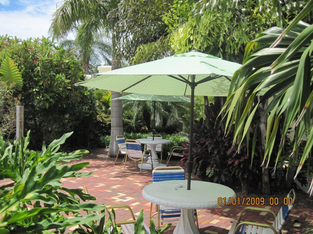 a table and chairs with an umbrella on a patio at The Grove in Delray Beach