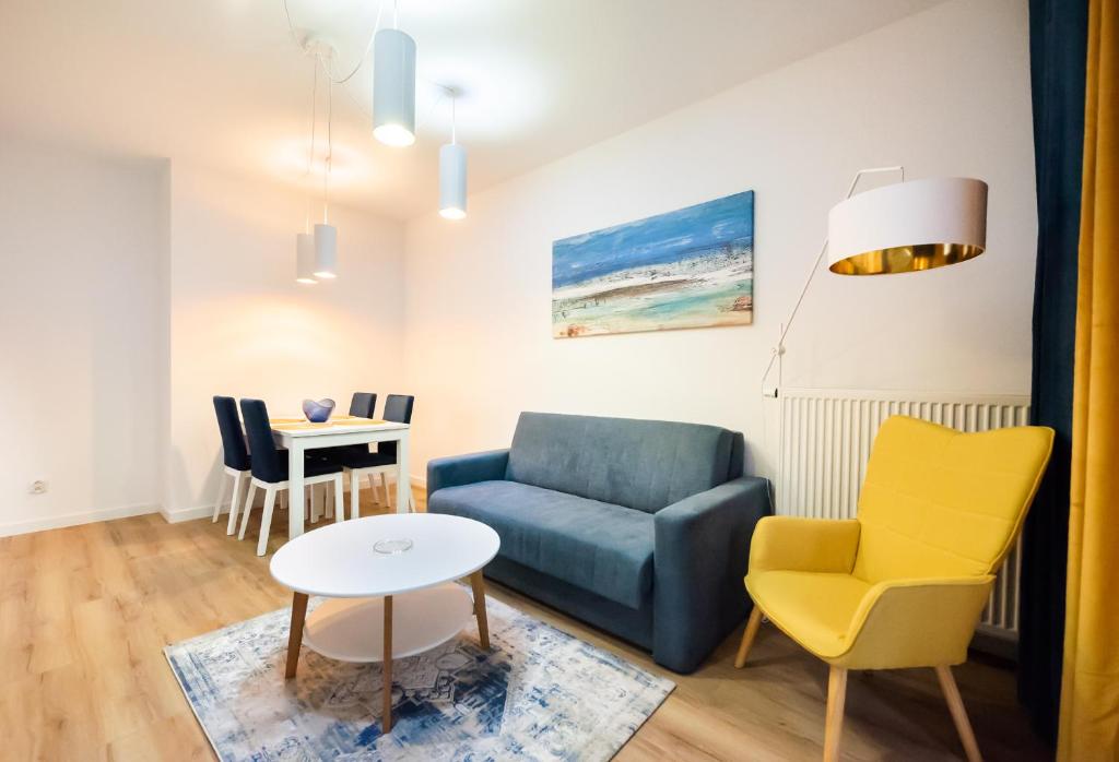 ein Wohnzimmer mit einem Sofa und einem Tisch in der Unterkunft Bliska Wola Navy Blue Business Apartment in Warschau