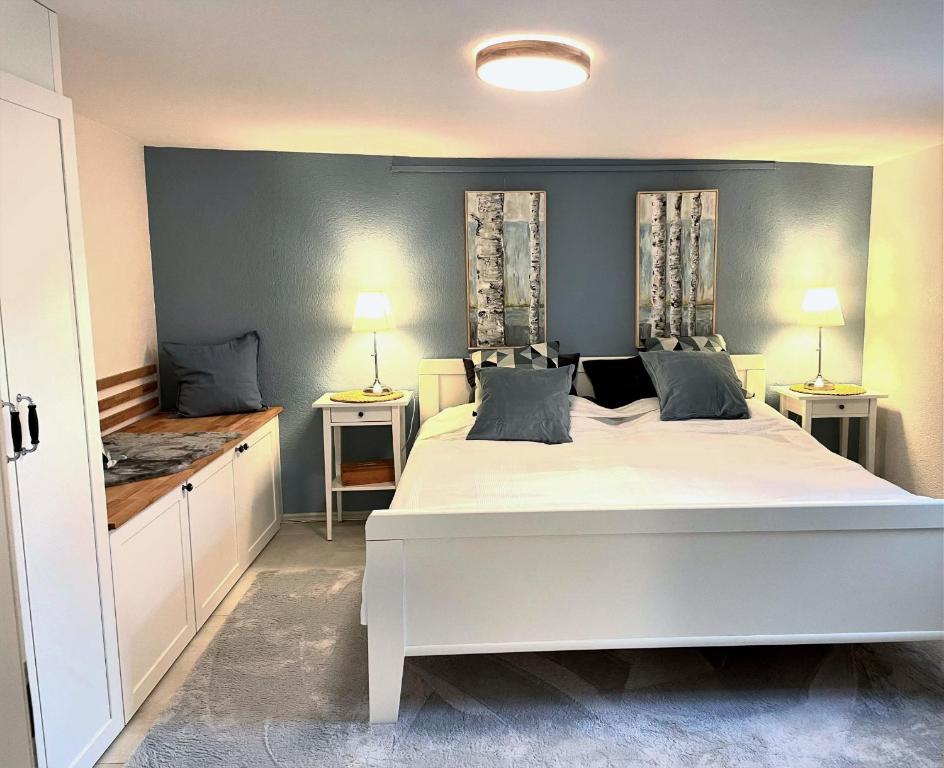 een slaapkamer met een groot wit bed en 2 lampen bij Ferienwohnung Graf in Tübingen