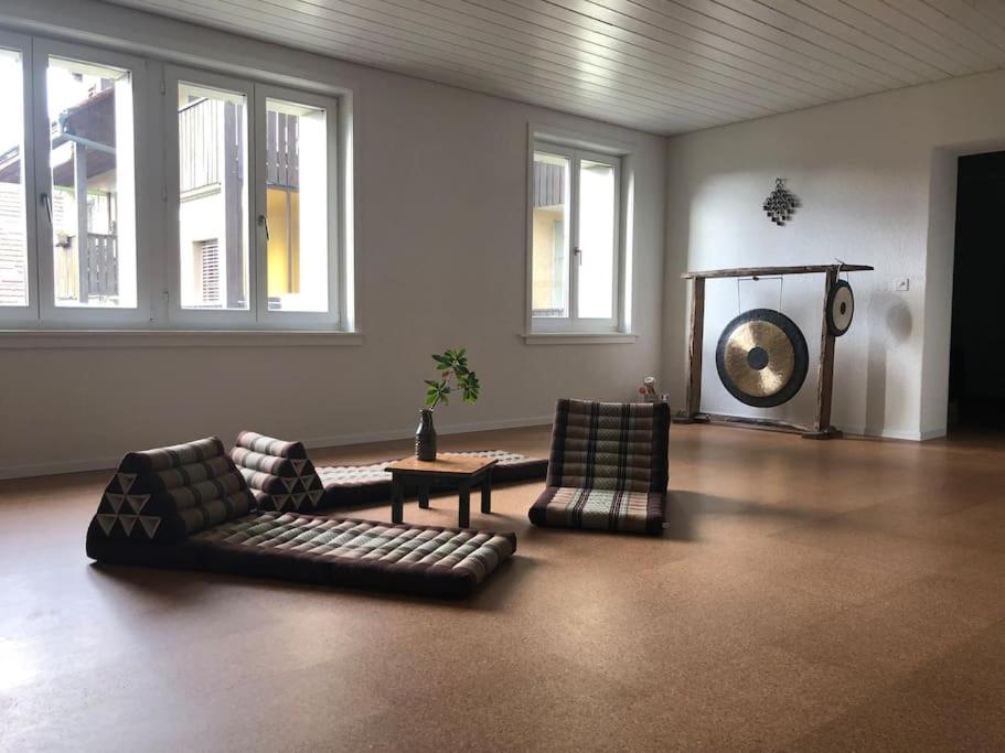 a living room with two couches and a table and windows at Wohnung in Burgdorf beim Schloss in Burgdorf