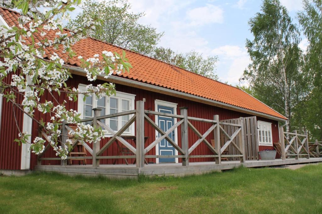 a red barn with a wooden fence around it at Skillingaryds Gård in Skillingaryd