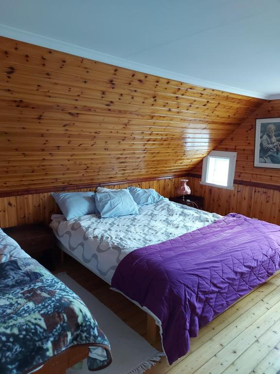 1 dormitorio con 1 cama en una habitación de madera en Mariannelund cottage, en Mariannelund
