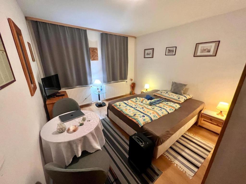 a small hotel room with a bed and a table at Penzión Evka in Poprad