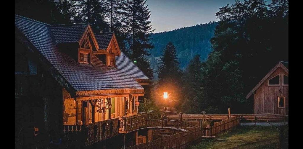 a large wooden house with a light on it at Ferienhaus Häxenäscht mit Sauna, Hotpot und Schopf mit gemütlichem Stübli und Pizzaofen 