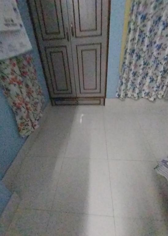 a room with a door and a tiled floor at AKSHITA Guest House in Guwahati