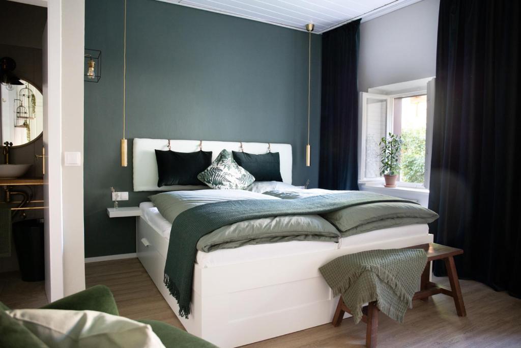 a bedroom with a bed with a blue wall at Privatzimmer - Sieben an der Donau in Ottensheim
