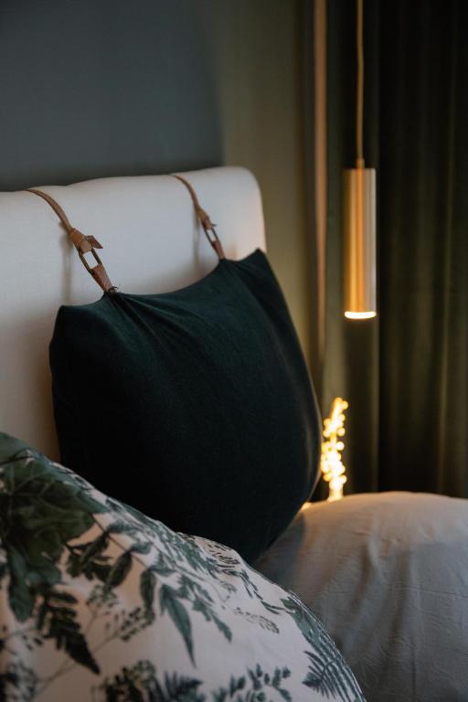 ein schwarzes Kissen auf einem Bett neben einer Lampe in der Unterkunft Privatzimmer - Sieben an der Donau in Ottensheim
