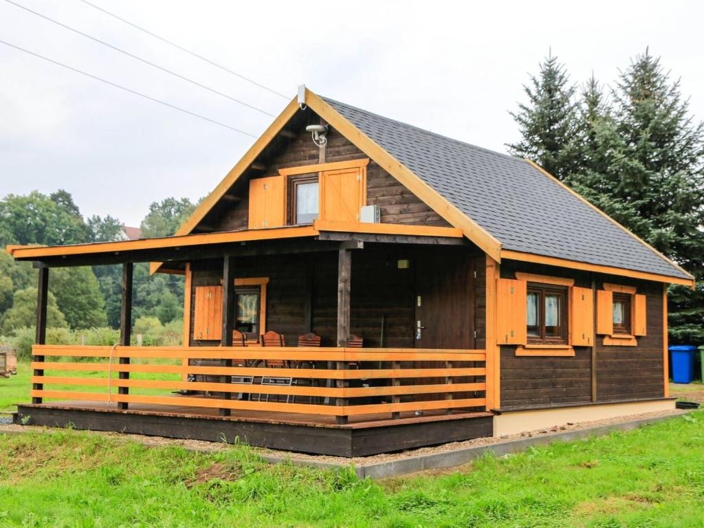 une grande maison en bois avec une grande véranda dans l'établissement Uroczysko Trzcińsko, à Trzcińsko
