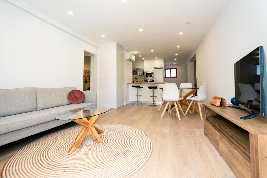 a living room with a couch and a table at URBANIZACION CON PISCINA ARNELAS SANXENXO in Sanxenxo