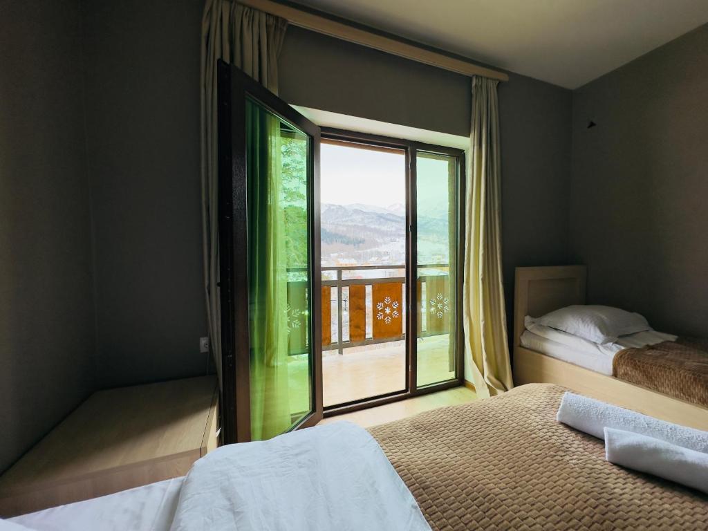 Schlafzimmer mit einem großen Fenster mit Aussicht in der Unterkunft Villa B Barleon-Bakuriani in Bakuriani