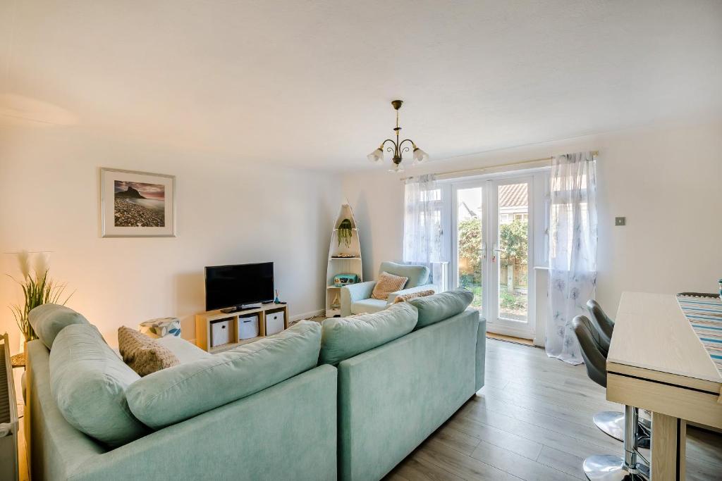 a living room with a blue couch and a television at 44 West Front Road in Bognor Regis