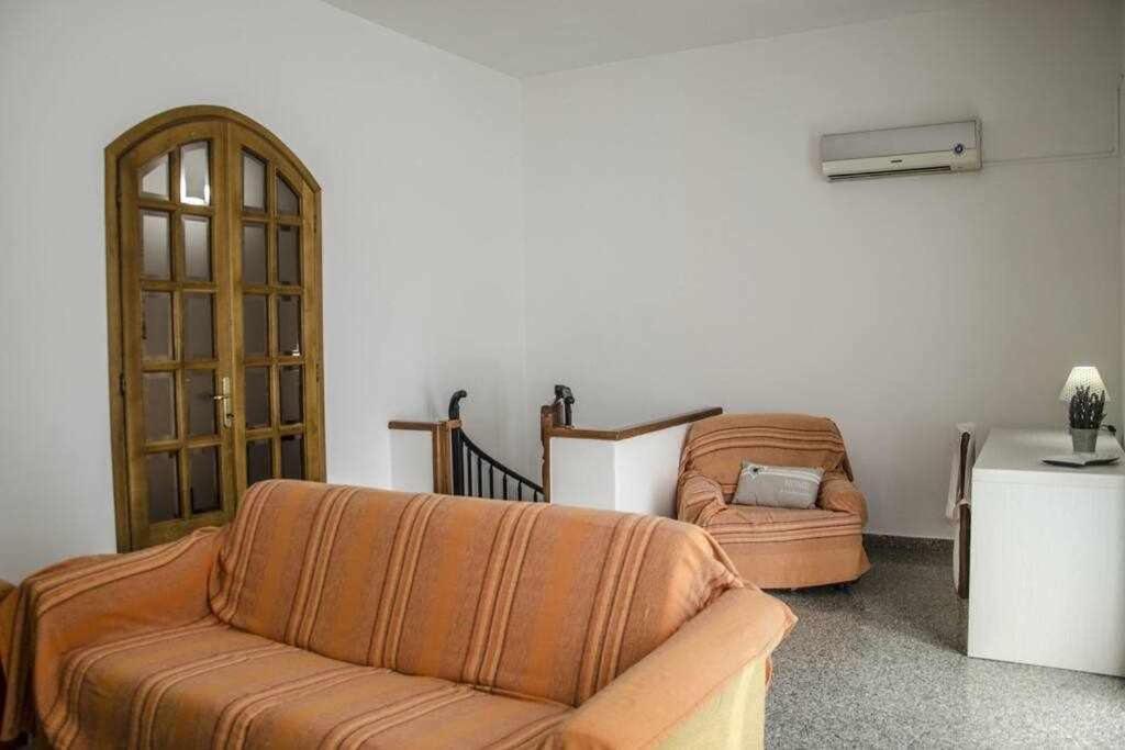 un soggiorno con divano e sedia di Trilocale a 300 metri dal mare Gambero ad Alghero