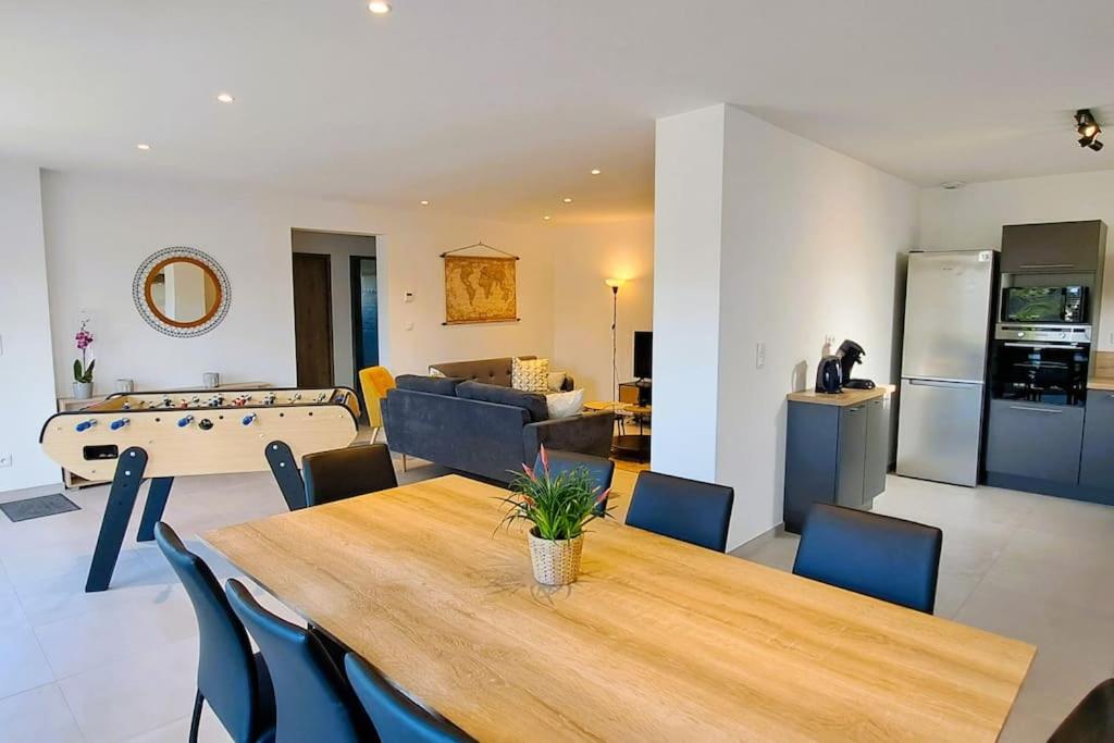 a dining room and living room with a table and chairs at La Petite Loge à Azay-le-Rideau in Azay-le-Rideau