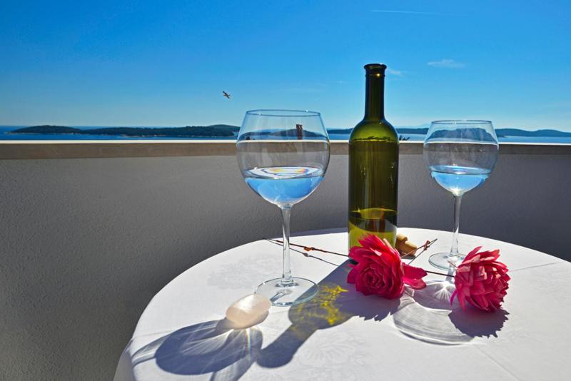 una mesa con dos copas de vino y una botella de vino en Sunset apartments, en Hvar