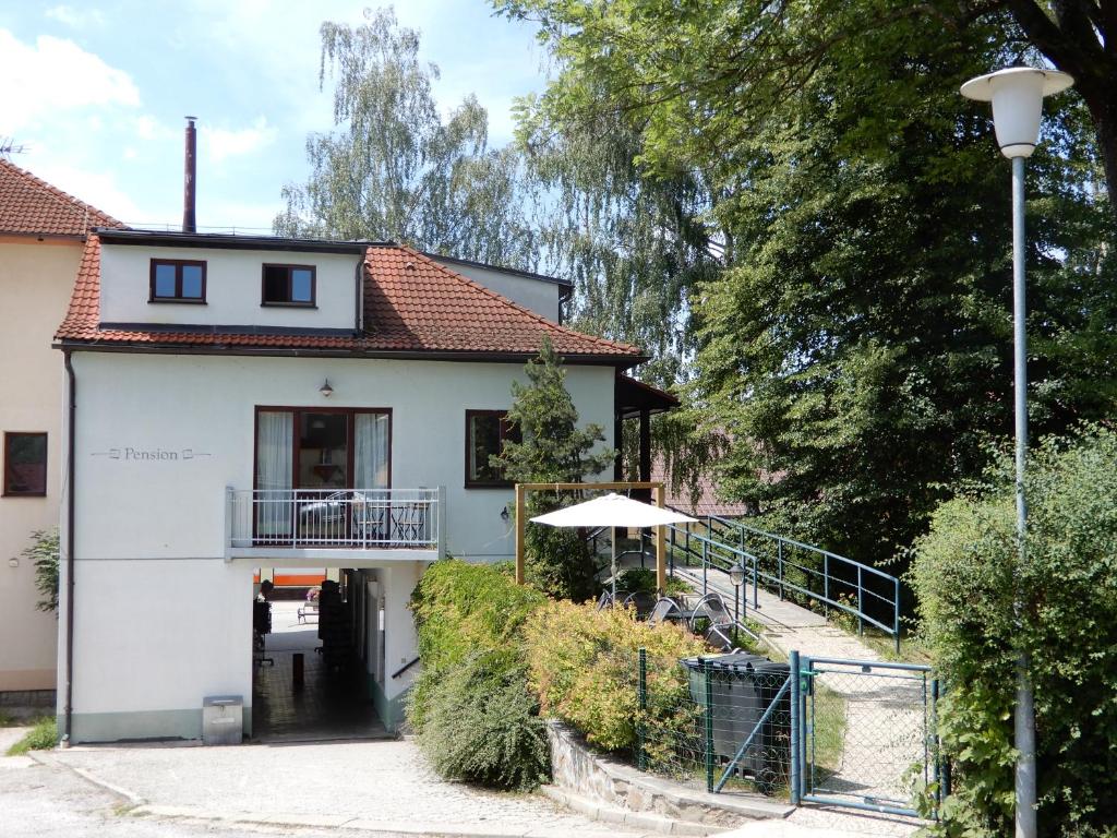 Dieses weiße Haus verfügt über eine Veranda und einen Balkon. in der Unterkunft Pension Terezka in Frymburk