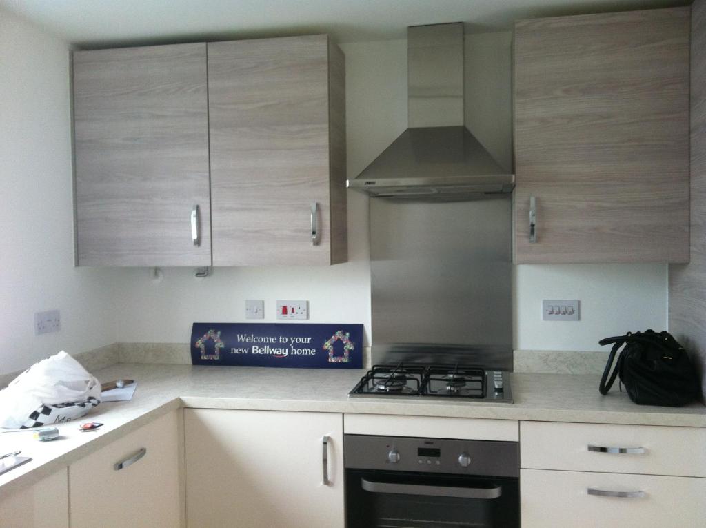 a kitchen with white cabinets and a stove top oven at sen in Liverpool