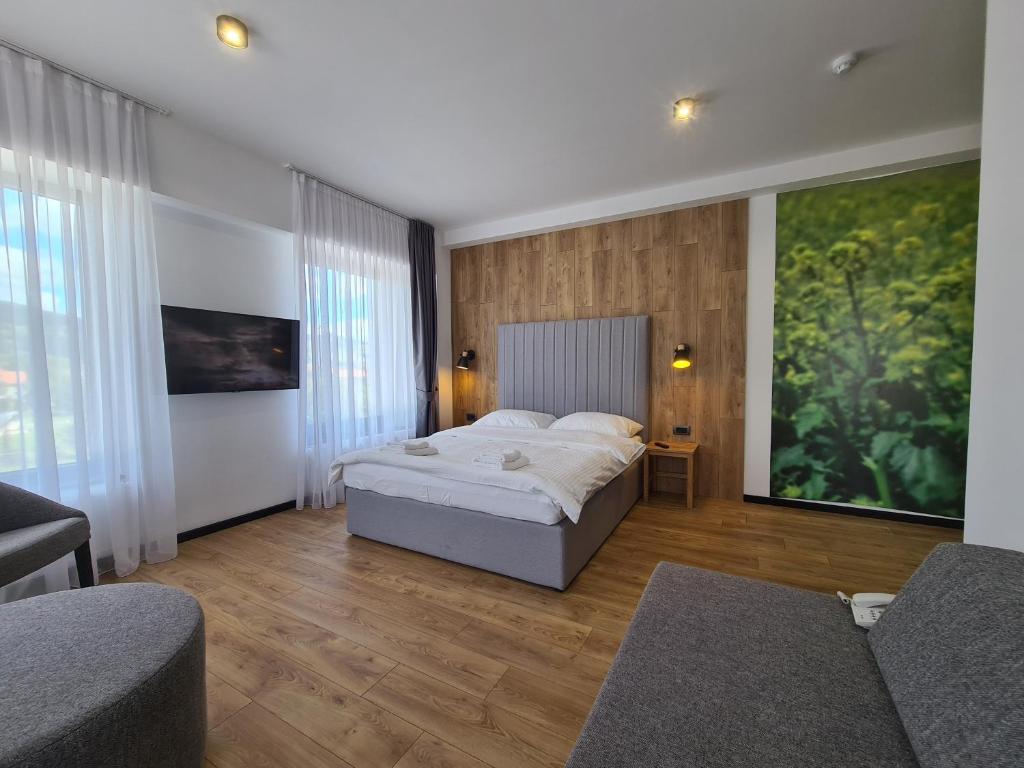 a bedroom with a bed and a large painting on the wall at Motel BTG in Tomislavgrad