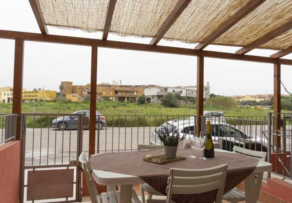 d'une table et de chaises sur un balcon avec vue sur le parking. dans l'établissement Appartamento a 200 metri dal mare Granseola, à Alghero