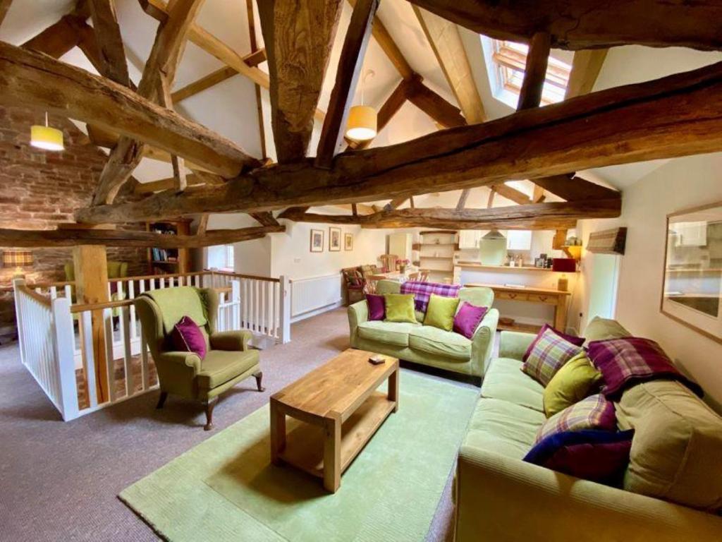 a living room with two couches and a table at Stunning barn minutes from the Lake District in Penrith