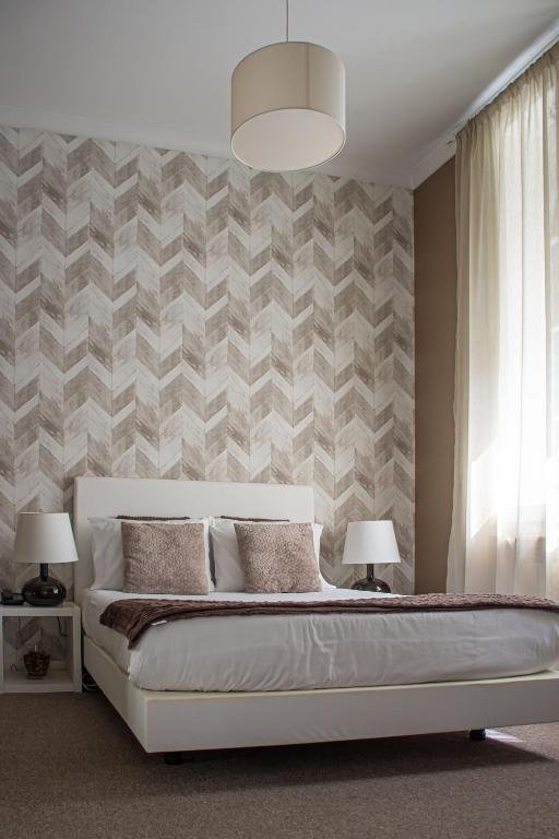 a bedroom with a bed and two lamps and a wall at O'Porto Seven - Guest House in Porto