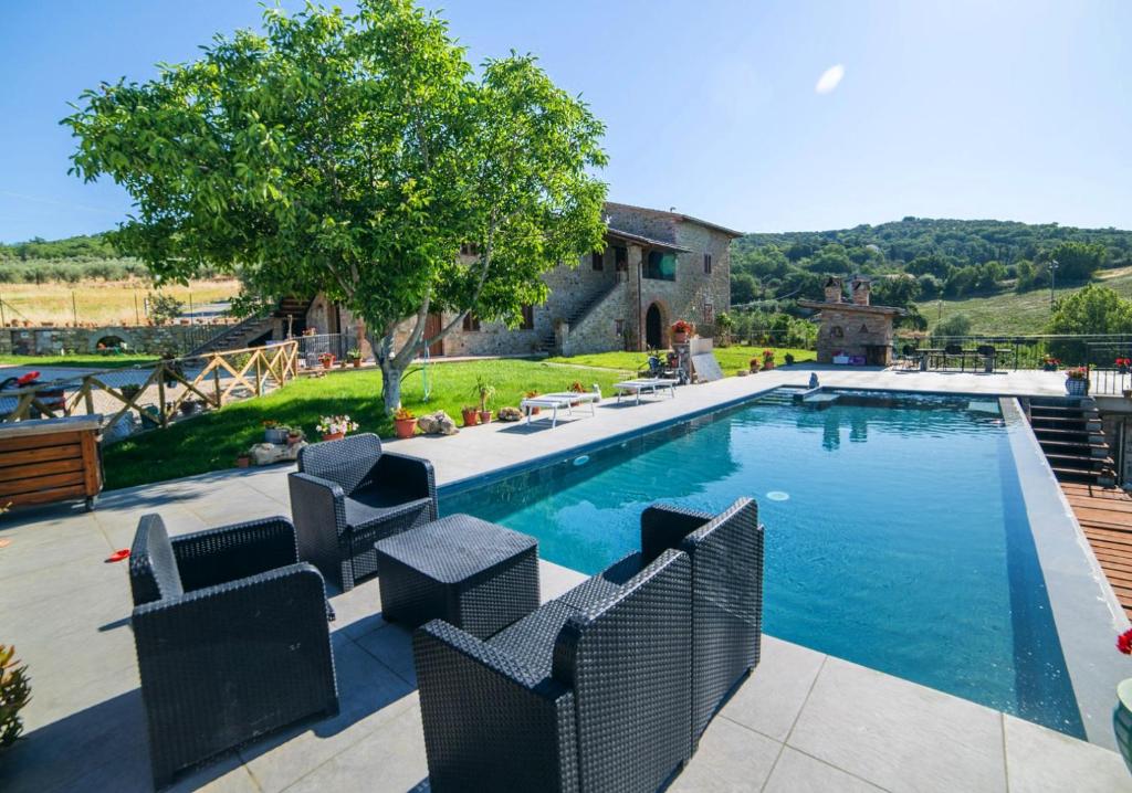 - une piscine avec des chaises en face d'une maison dans l'établissement Villa aquila, à Agello
