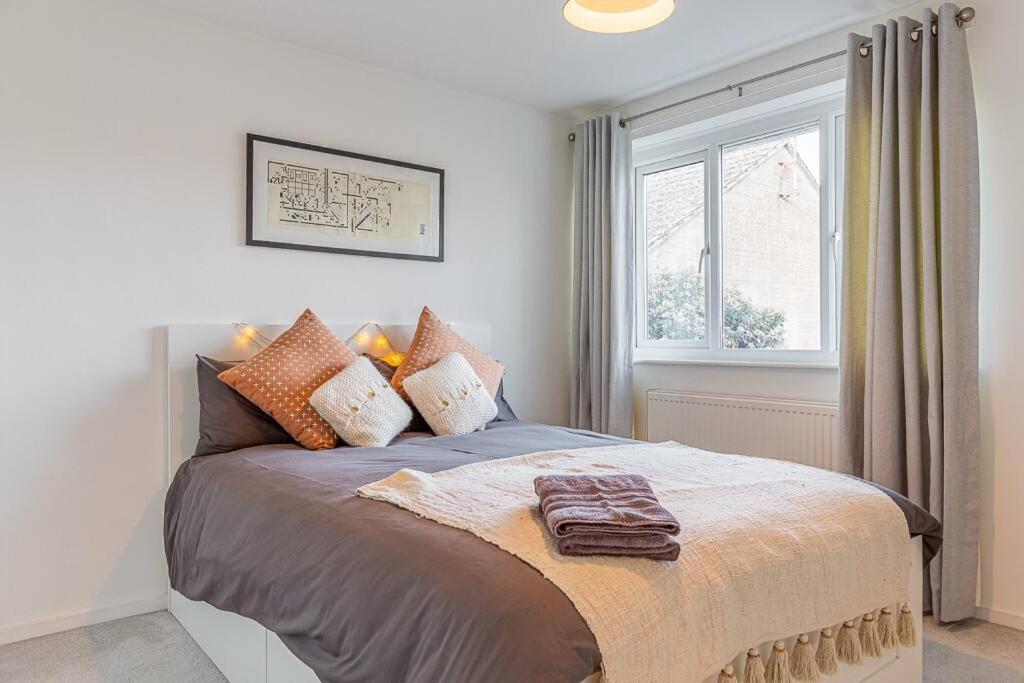 1 dormitorio con cama con almohadas y ventana en Modern 2 BD w/ Garden in the Heart of Tetbury! en Tetbury