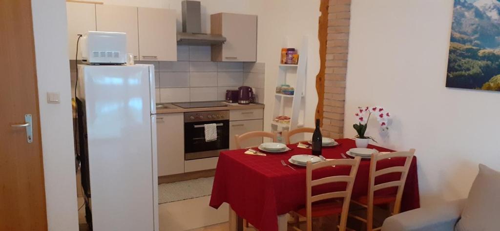 eine kleine Küche mit einem Tisch und einem roten Tischtuch in der Unterkunft Apartman Vigo,Fužine in Fužine