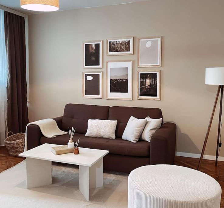 uma sala de estar com um sofá e uma mesa em City Center - TERRA Apartment em Pristina