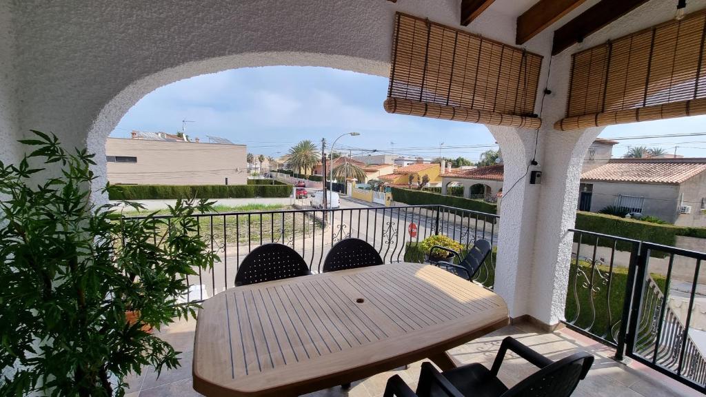 patio con mesa de madera y sillas en el balcón en Hello Oliva Beach Alter, en Oliva