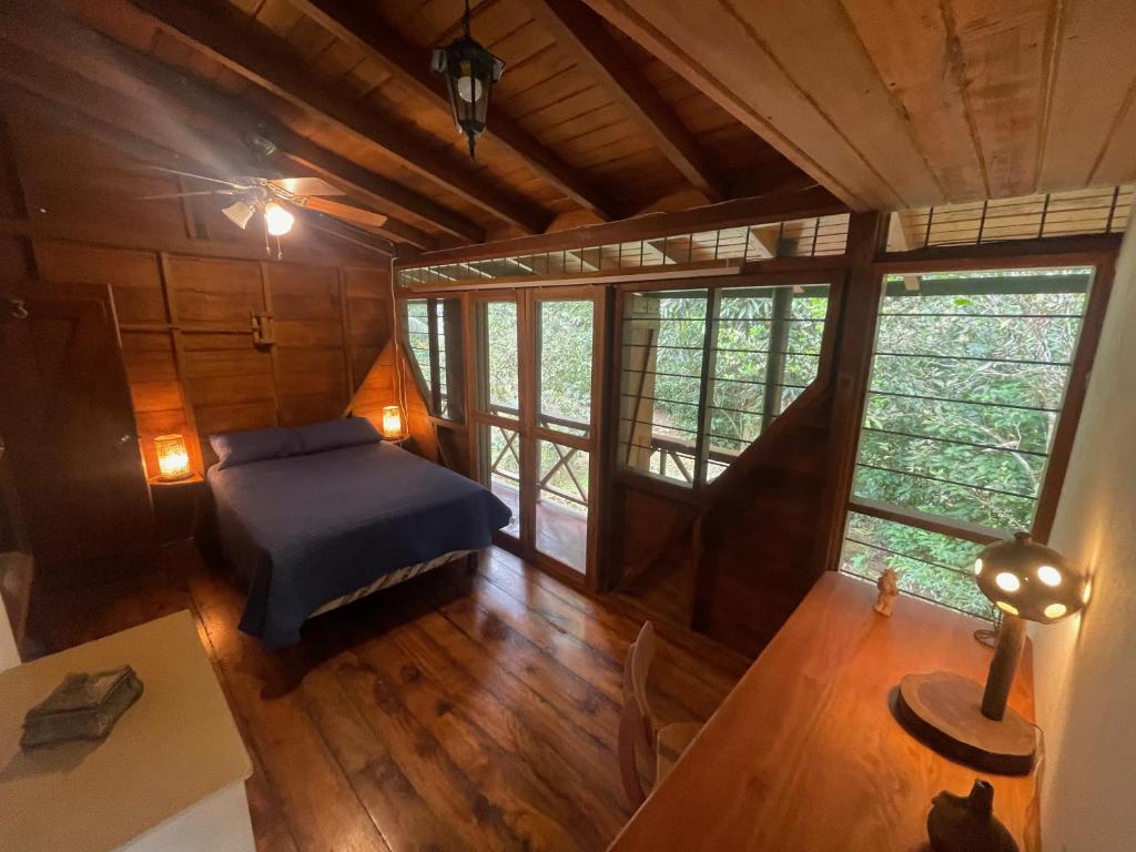 a bedroom with a bed and a table in a room at Caoni riverside Lodge in Puerto Quito