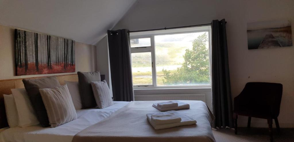 um quarto com uma cama com duas toalhas em The Dundonnell Hotel em Dundonnell