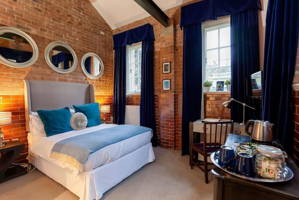 a bedroom with a bed and a brick wall at Duclos (Private Ensuite room) at Bicester Heritage in Bicester