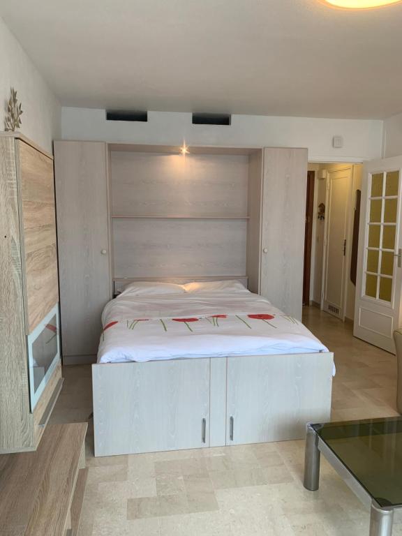 une chambre avec un grand lit blanc dans une pièce dans l'établissement IDEAL SEJOUR à MANDELIEU, à Mandelieu-la-Napoule