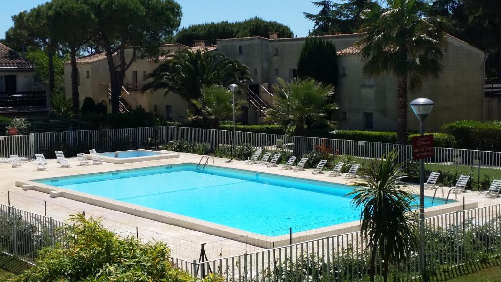 a swimming pool with lounge chairs around it at Eleuthera- 174- Appart en rez de jardin- 4pers in Cap d'Agde