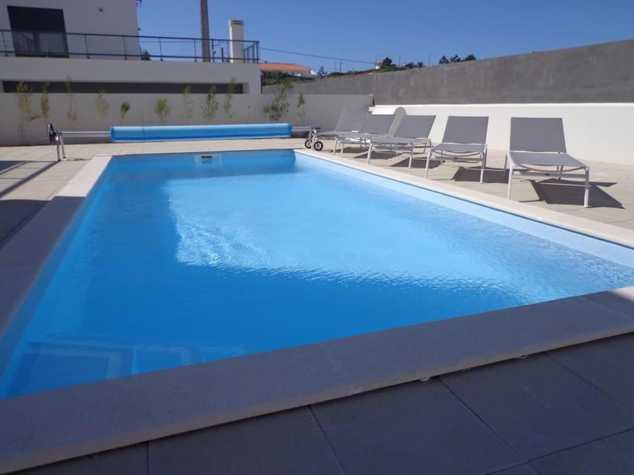 a large blue swimming pool on top of a building at Villa met het rustige strand van Salgado op wandelafstand in São Martinho do Porto