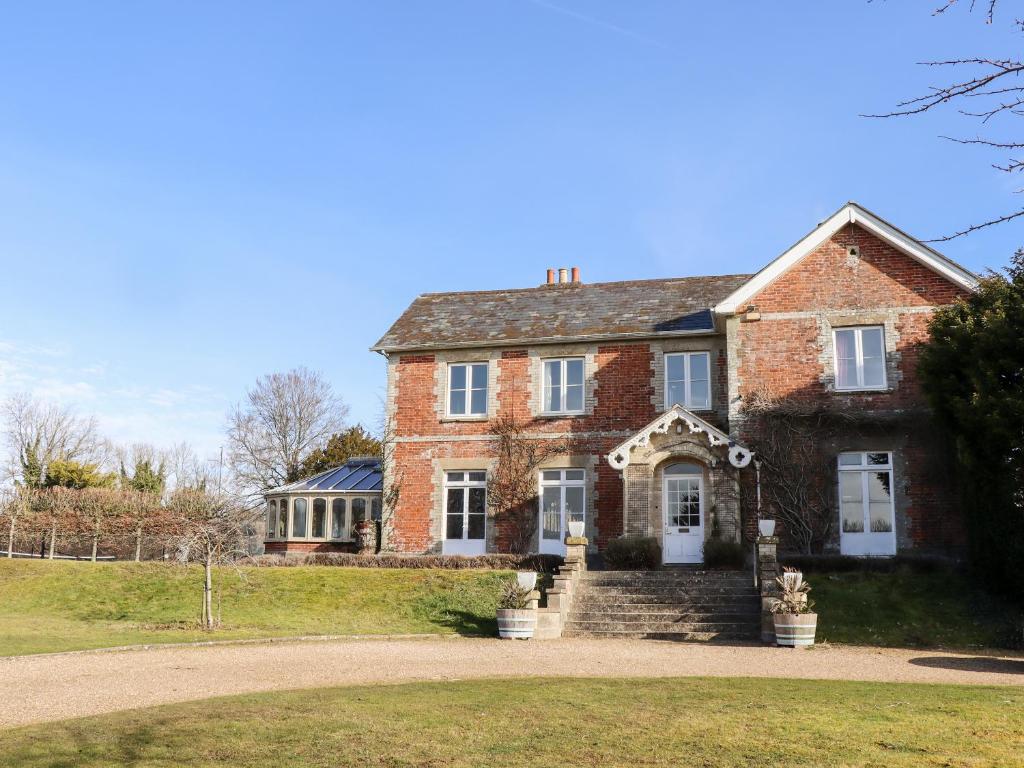 an old brick house on a grassy field at The Downwood in Blandford Forum